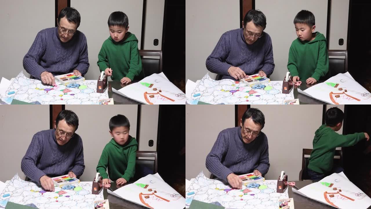 亚洲高级男子和孙子一起在家制作手工艺品