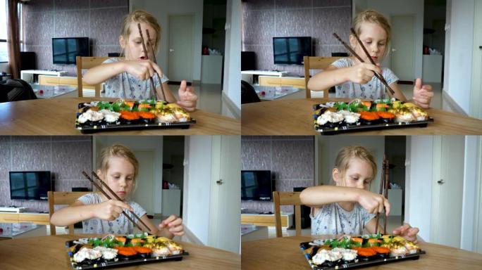 小女孩试着吃一排包裹的寿司
