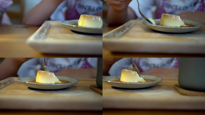 小女孩在餐馆吃甜点。盘子上的布丁特写。