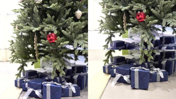 百货公司的圣诞装饰品。圣诞树是绿色的。树下有许多深蓝色的礼物。从上到下倾斜击球。