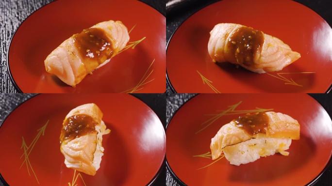 寿司配米饭，烤猪肉和酱汁放在转盘上。日本料理与微距拍摄。
