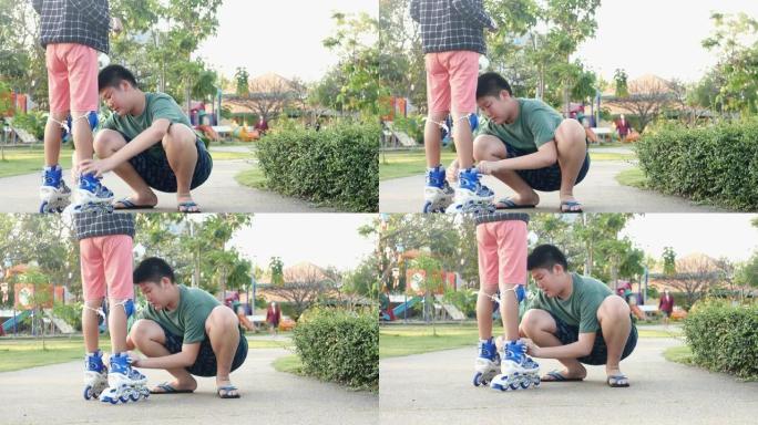 亚洲男孩检查他的妹妹滑板鞋，然后早上在公园里用太阳光玩耍，哥哥总是为爱而支持他的女孩。