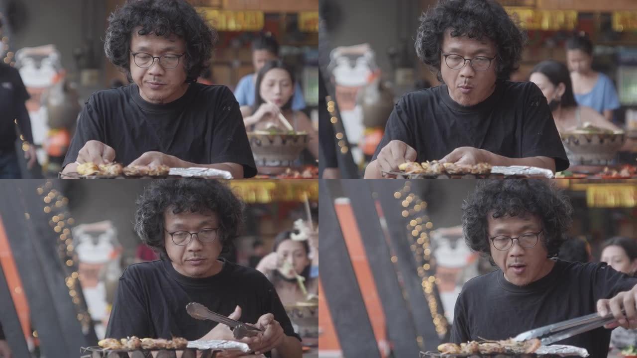 肖像40-50岁的亚洲男子在新年节日与海烧烤派对，流行街头美食海鲜在泰国。