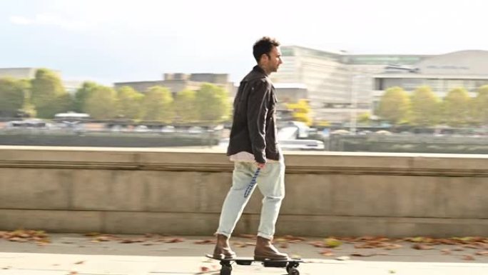 35岁左右的男性沿着泰晤士河堤岸玩滑板