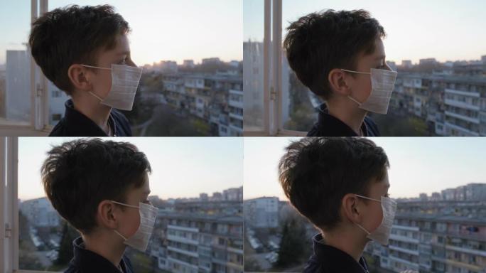 肖像男孩拿着医疗面具脸检疫露台房子镜头耀斑看起来可靠的距离蓝天城市日落。冠状病毒病毒新型冠状病毒肺炎