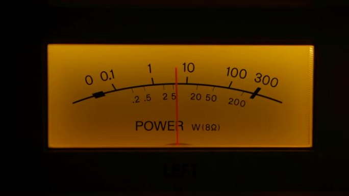黄色控制旧模拟收音机上的仪表板。老式电子声音音频设备上向上和向下的指示针运动读数水平的极端特写。特写