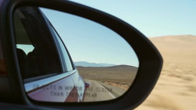 POV侧视图乘客后视镜显示开阔的沙漠道路