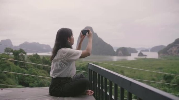 亚洲女孩用智能手机拍照。