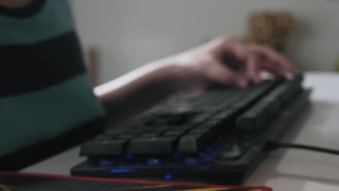 男孩的手在家里用电脑玩网络游戏，生活方式的概念。