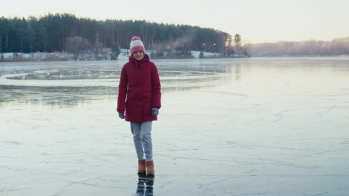 一个女人在寒冷的日子里走在冰冻的湖上