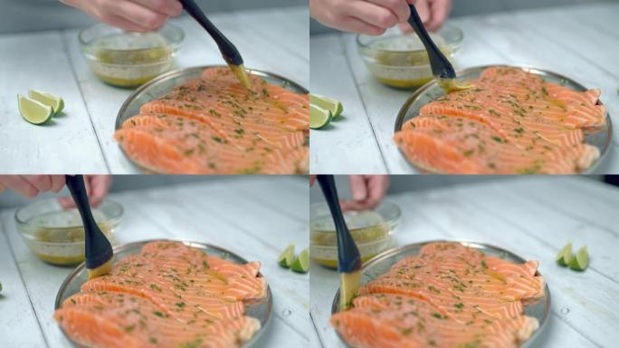 使用涂抹刷用腌料酱刷生鲑鱼的特写镜头。用融化的黄油，大蒜，蔬菜刷鲑鱼片。准备鲑鱼在烤架上烹饪的概念。