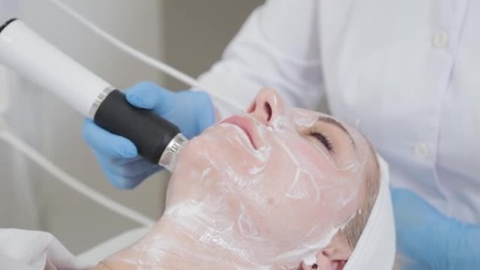 专业美容师在美容院用羧化治疗仪做面部按摩