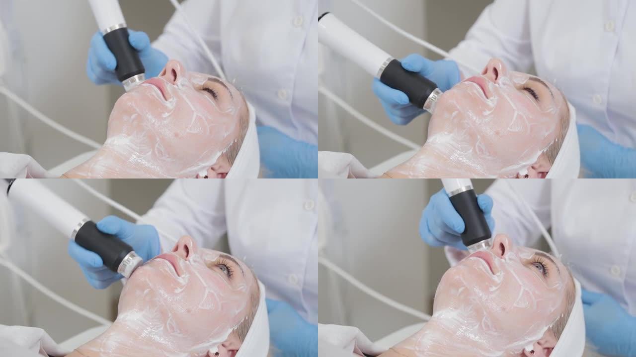 专业美容师在美容院用羧化治疗仪做面部按摩