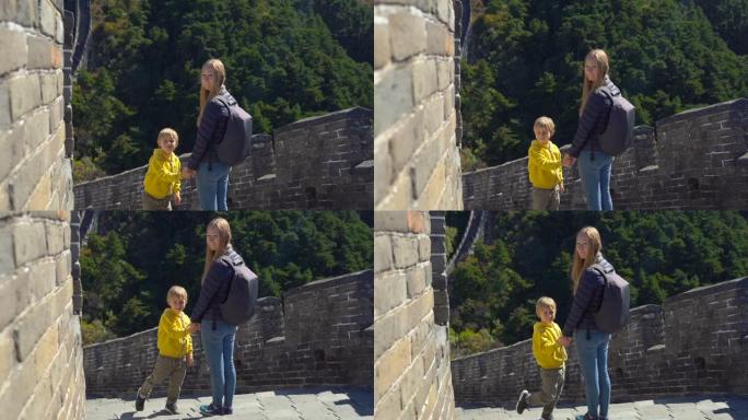 慢镜头拍摄一个快乐的年轻女子和她的小儿子站在中国长城上