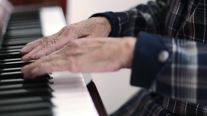有着深深的皱纹的老女性手的特写弹钢琴。