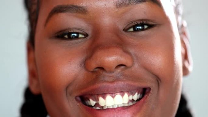 快乐的年轻黑人妇女微笑。20多岁的非洲女孩的极端特写脸