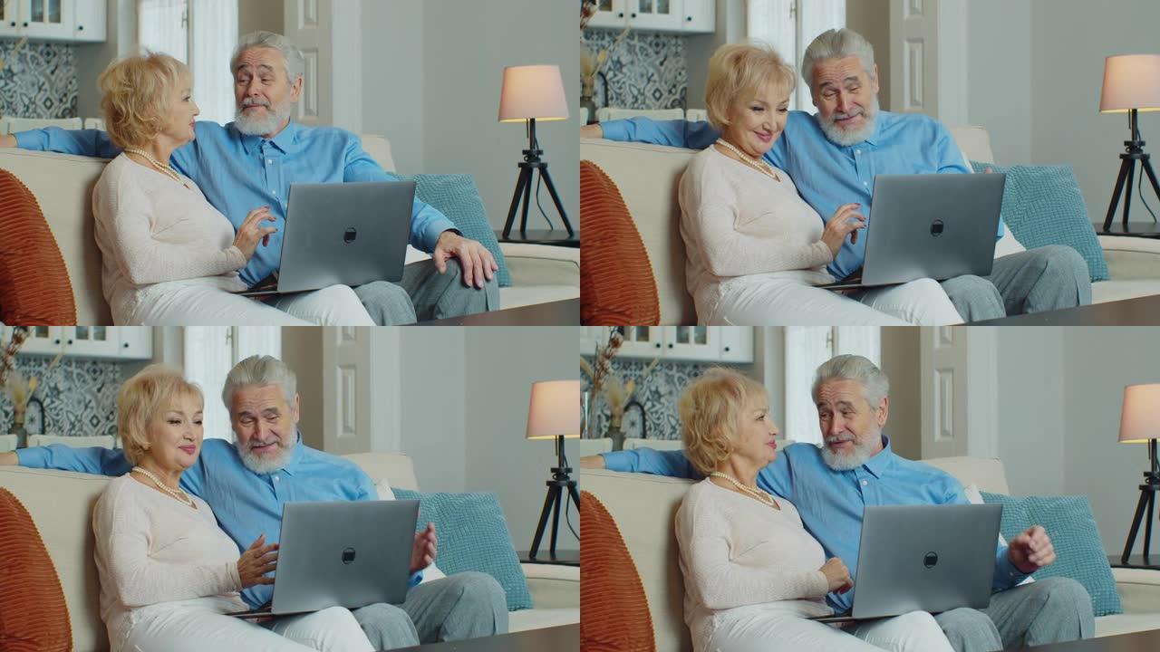 老退休夫妇用笔记本电脑上网购物选择销售优惠，老年家庭祖父母放松地看着电脑屏幕坐在家里的沙发上。冠状病
