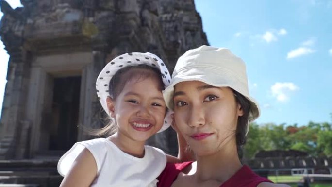 一家人正在泰国的一座老庙里自拍。