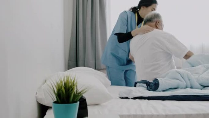 揭露护士帮助老人起床的镜头。