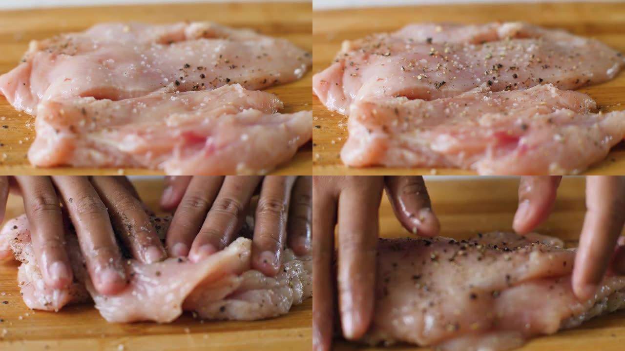 用盐和黑椒粉调味的木板上的鸡胸肉。