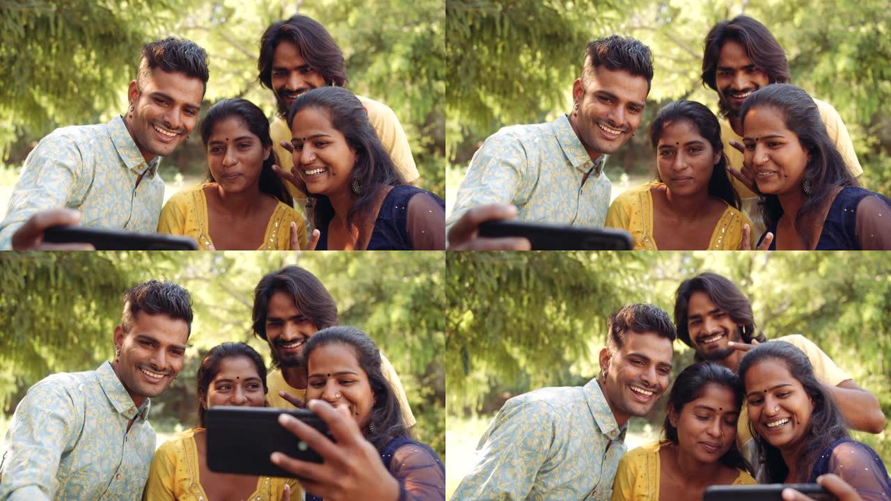 使用智能手机手机在自然公园户外的印度朋友
