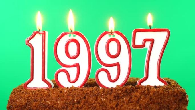 蛋糕与数字1997点燃的蜡烛。上个世纪的日期。色度键。绿屏。隔离