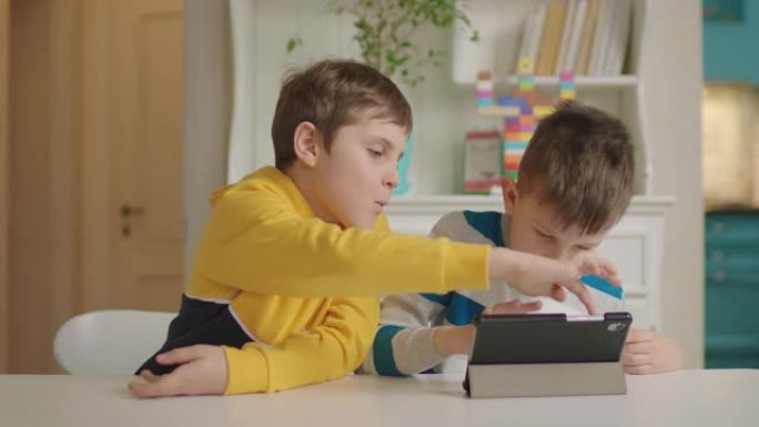 两个自闭症男孩使用一台平板电脑进行教育应用。自闭症谱系障碍在线教育。