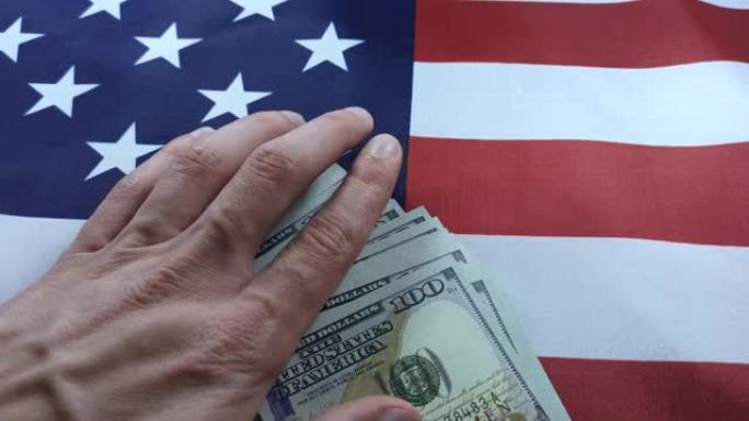 腐败系统概念。上面印着美元的美国国旗。男人的手拿走了钱。美国的政治变革。汇率，经济危机。