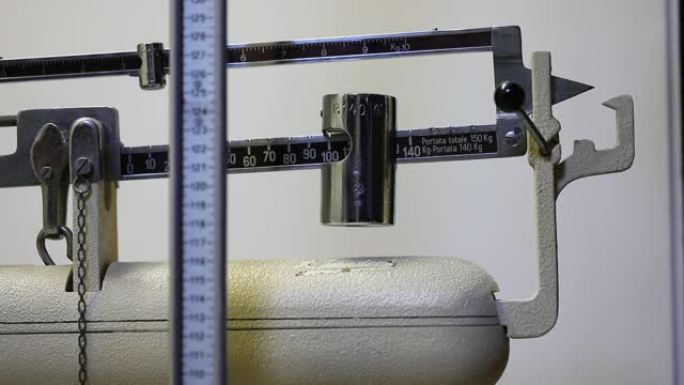 营养师用浴室秤测量体重的手