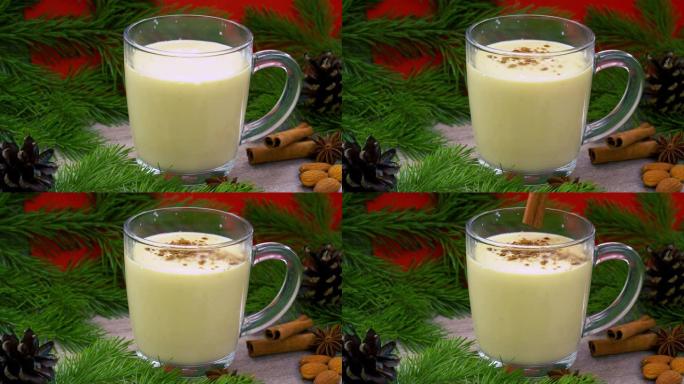 传统节日饮料蛋酒。基于生鸡蛋和牛奶的甜饮料。圣诞鸡尾酒配磨碎的肉豆蔻和肉桂。具有锥体的云杉分支的背景