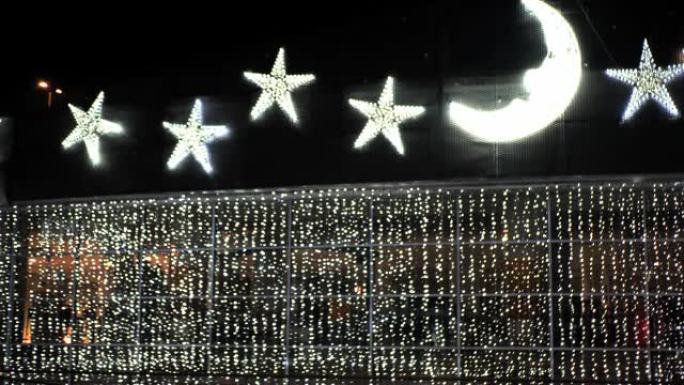 圣诞晚会装饰: 由白炽灯制成的巨大金星和新月在黑暗中发光明亮。