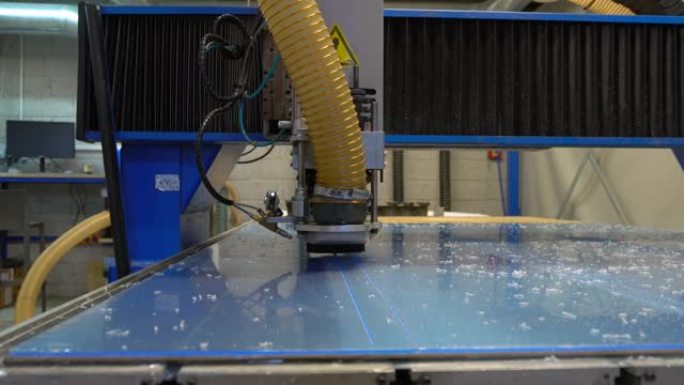 数控铣刀在机器人生产线上切割塑料片。