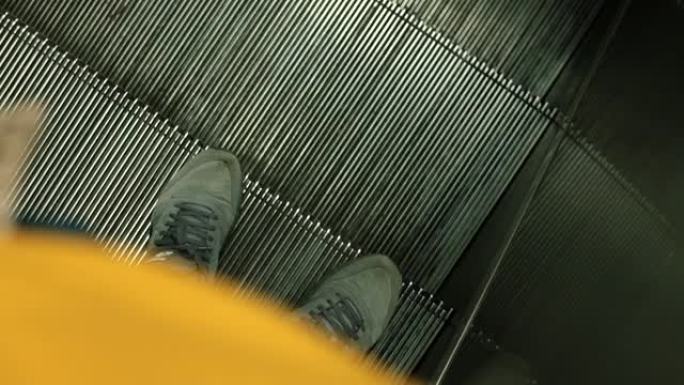 男子的脚踩在自动扶梯上。城市中的行人运动。