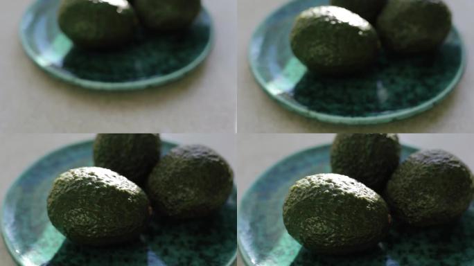 成熟哈斯鳄梨的视频剪辑放在绿色陶瓷盘子上午餐