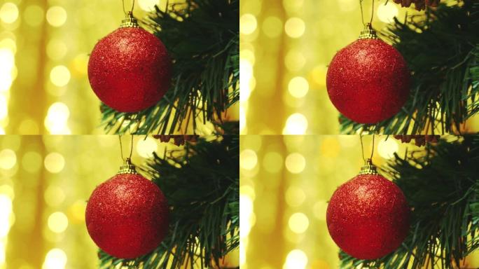 红色泡泡装饰品挂在带有bokeh背景的圣诞树上。