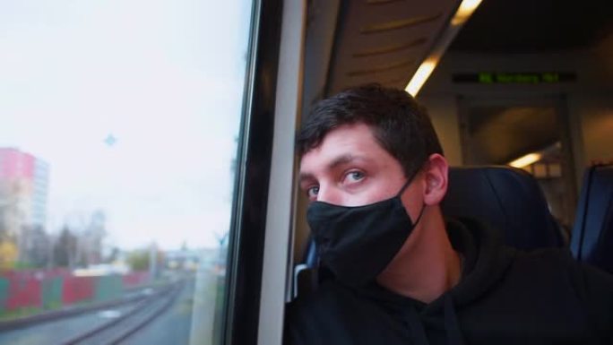 一个戴着面具的男人在火车上移动到车站。运输乘客