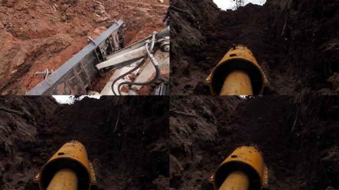 挖掘机将地面倒在用套管保护的管道上