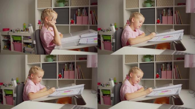 跟踪侧视中拍美丽的金发小女孩坐在家里的桌子上学习。小学生用记事本写作，桌上打开课本