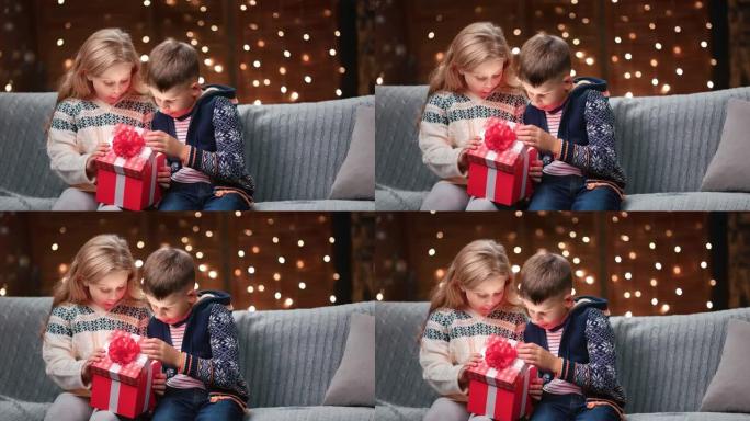 印象深刻的兄妹打开圣诞红色礼品盒。在红色乌鸦4k电影摄像机上拍摄