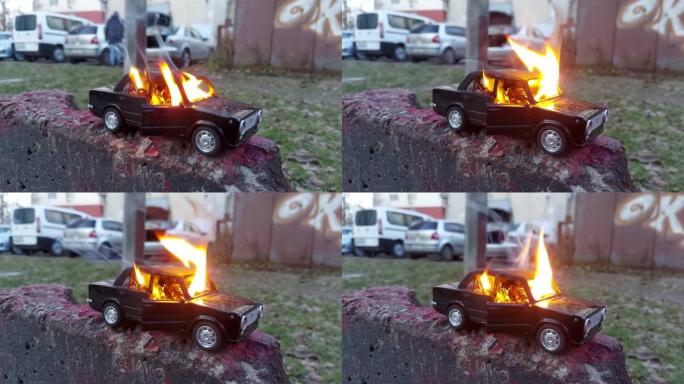 儿童车着火了。在操场的背景上点燃儿童玩具车。一场危险的火灾游戏。玩具车着火了。