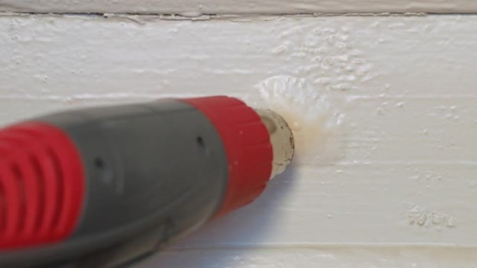 木质门窗的简单廉价修复。恢复木匠用热风枪高温和刮铲从涂漆木板表面剥离油漆。家居项目DIY家居室内工艺