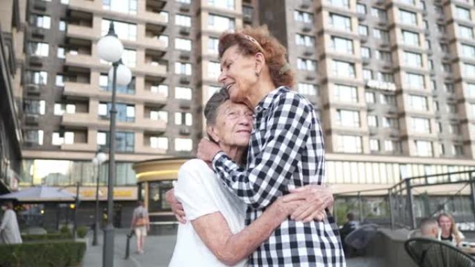 高加索老年妇女在城市中，以爱心，关怀，帮助，支持和同情拥抱母亲和女儿。不同年龄段的真诚家庭结合聊天开
