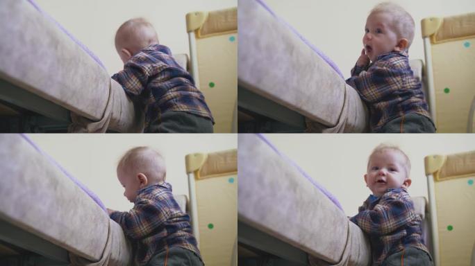 穿着暖和衣服的小婴儿爬上房间里的大软床