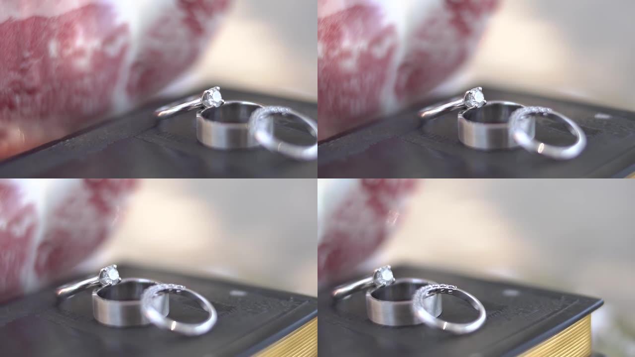 在瓷器茶壶特写旁边的书的皮革封面上的结婚戒指