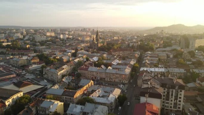 日出时在一个神话般的城市进行空中飞行。早晨在乌克兰的利沃夫小镇。地平线上的太阳光线落在房屋上。早晨城