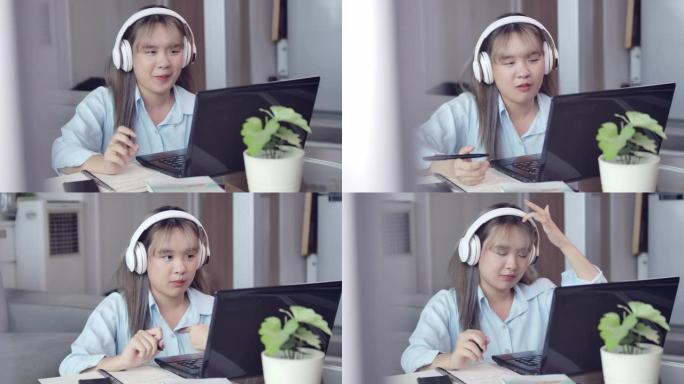 在COVID检疫期间，一名亚洲长发少女正在客厅学习家庭在线学习。