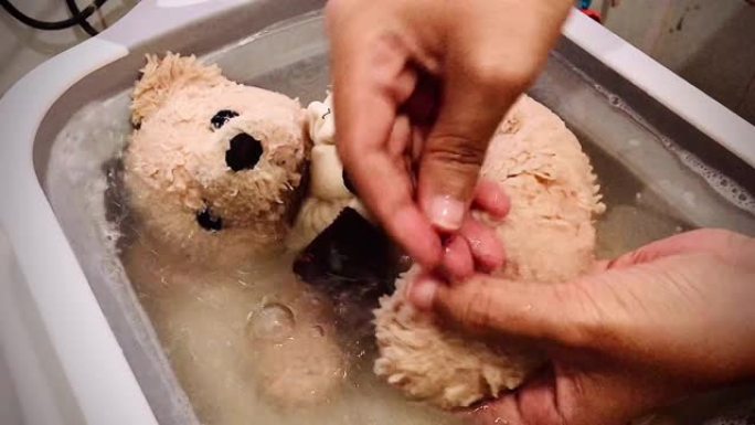 棕色玩具熊在浴缸里洗澡的镜头