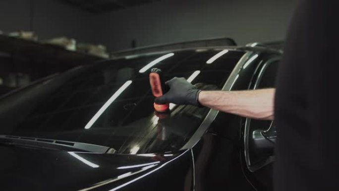 专业汽车陶瓷工人在车窗上涂一层陶瓷防护雨罩。概念来自: 纳米保护，不同的配件，长保护