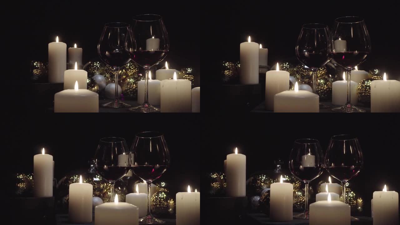 多莉·肖尔 (dolly shot) 在燃烧的蜡烛，圣诞节和新年装饰品的背景下配上红酒的玻璃杯