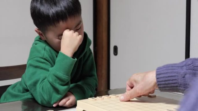 亚洲外公外孙在客厅玩将棋